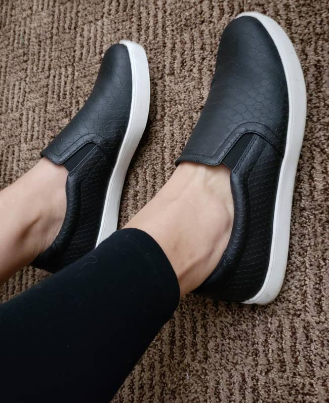 reviewer wearing the black slip ons