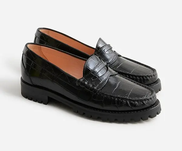 A pair of black loafers with chunky soles displayed against a neutral background