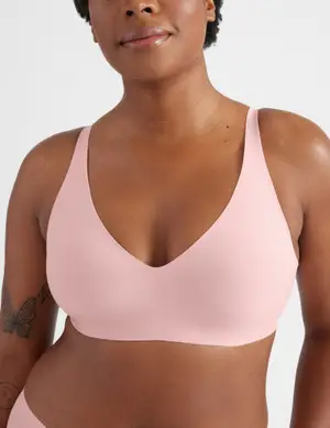 Model wearing a minimalist, seamless bra with wide straps, showcasing comfort-focused design